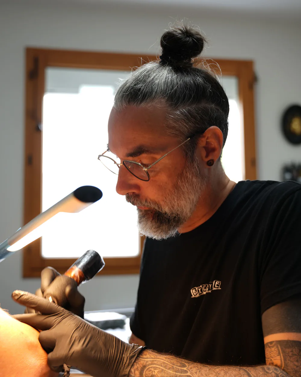 Cyrille Saley, tatoueur de 6'Ril Tattoo, en train de tatouer dans son studio privé à Troarn près de Caen