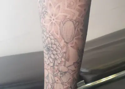 Tatouage floral fine line, dahlia et tulipes sur la jambe