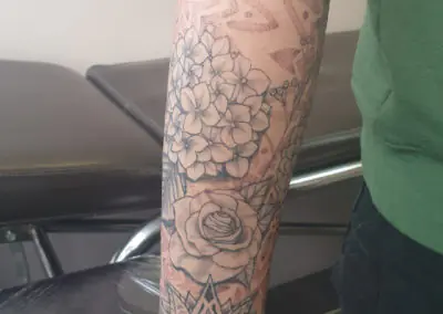 Manchette de tatouage floral, rose et hortensia en noir et gris