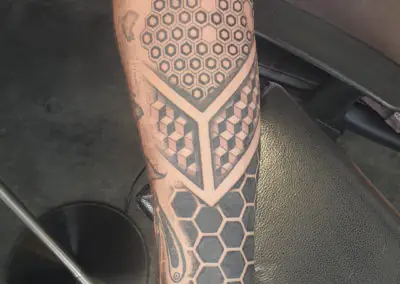 Tatouage géométrique d'hexagones en nid d'abeille sur la jambe