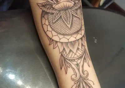 Tatouage lotus et mandala ornemental en dotwork sur l'avant-bras